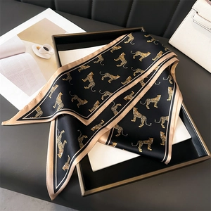 Elegant double-layer leopard print silk scarf on display tray with high-end luxury aesthetic