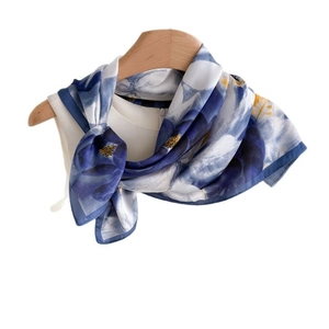 Elegant royal blue and white floral silk scarf displayed on a wooden hanger