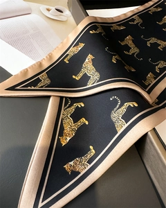 Detail of leopard print silk scarf with satin texture and elegant black gold finish