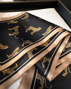 Detail of leopard print double-layered silk scarf with elegant satin finish and stripes