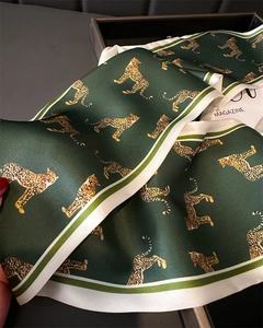 Close-up of silk leopard print scarf with striped borders and smooth texture