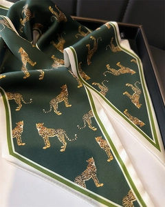 Detail of dark green leopard print silk scarf with satin finish on a luxury tray