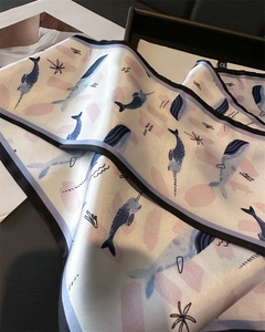 Detail of silk narrow scarf featuring hand-painted blue narwhal and whale print pattern