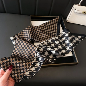 Close-up of double-sided silk scarf with orange plaid and geometric star patterns