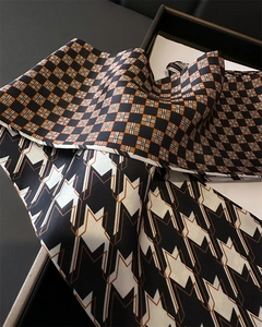 Detail of silk-texture scarves with geometric and checkered patterns on a tray