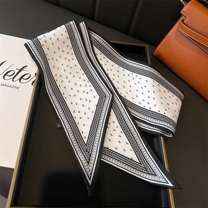 Detail of a black and white twilly silk scarf with star pattern and woven edge