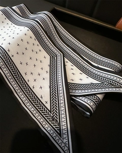 Detail of a minimalist black and white silk scarf with geometric cross patterns