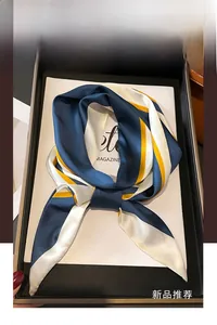 Détail d'un foulard en soie à rayures bleu marine et jaune dans son coffret