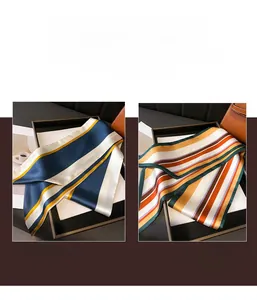 Détail de foulards étroits en soie à rayures géométriques en tons bleu et orange