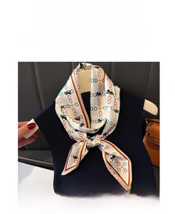 Détail d'un élégant foulard en soie à imprimé chaîne et cheval sur une veste