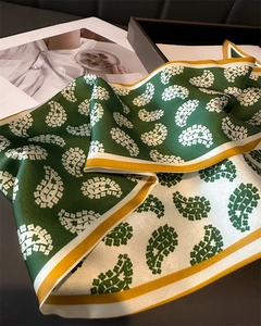 Detail of green paisley satin skinny scarf with contrast border and smooth silky texture
