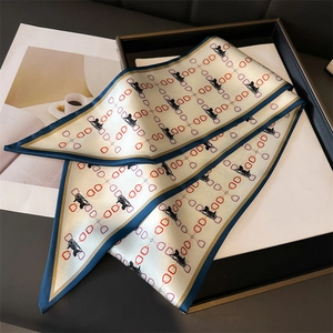 Vue détaillée du foulard en soie avec motif de calèche sur un plateau noir