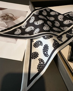 Detail of paisley pattern long silk scarves in black and white with contrast hem