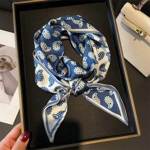Navy blue and white paisley silk scarf displayed in an elegant gift box with magazine