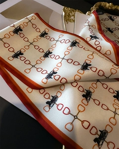 Détail de motifs de chaînes et de calèches sur une écharpe en soie élégante