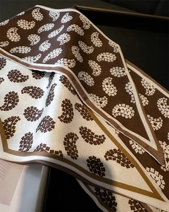 Close-up of a double-layered paisley silk scarf with coffee and cream pattern detail
