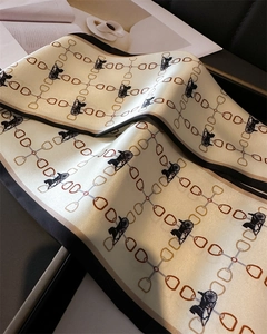 Détail d'un foulard en soie montrant le motif de chaîne vintage et l'ourlet