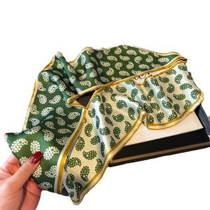 Green and white paisley silk scarf with yellow edges and smooth satin texture