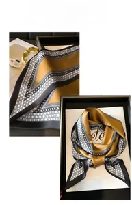 Detail of elegant mustard and black silk scarf with geometric patterns and neat stitching