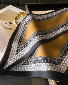 Close-up of a double-layer silk scarf with geometric honeycomb pattern and black borders