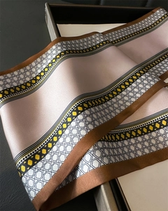 Macro shot of geometric pattern silk twilly with pink, yellow and black honeycomb design