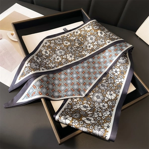Élégant foulard twilly en soie noir et blanc drapé sur un sac à main en cuir de luxe