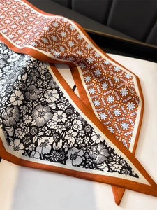 Détail d'un foulard en soie imprimé double face aux motifs floraux et géométriques