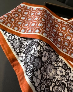 Détail d'un foulard en soie double face avec motifs géométriques et texture satinée