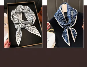 Detailed view of paisley silk scarves in cream and navy blue worn around the neck