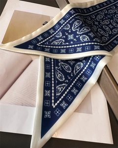 Detail of navy paisley polyester scarf featuring silky texture and elegant white border