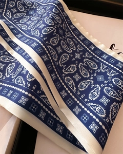 Detail showing classic navy blue paisley pattern on glossy long silk scarf texture