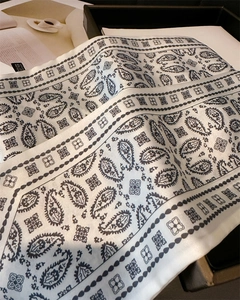 Detail of silky paisley scarf showing smooth satin texture and elegant floral pattern