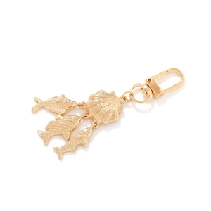 Creative gold ocean shell keychain with three fish charms and lobster clasp on white background