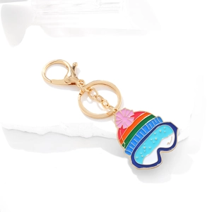 Regenbogen-Emaille-Skimütze Schlüsselanhänger mit goldenem Verschluss auf Marmor