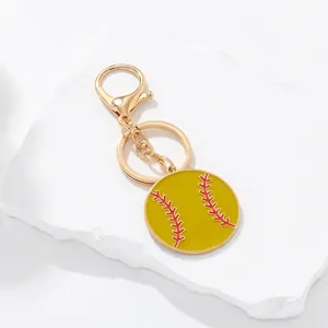 Creative baseball keychain with yellow enamel charm and golden metal hook on white background