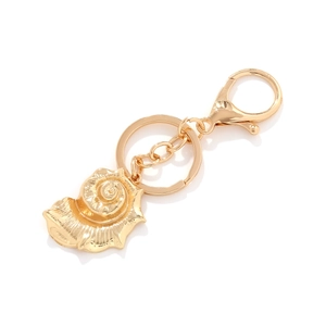 Golden ocean shell keychain with spiral conch pendant on a crisp white background