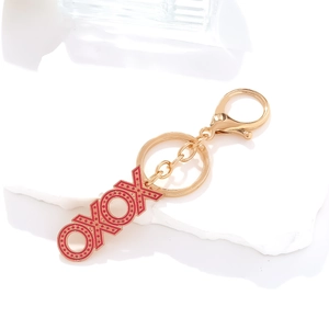 Golden XOXO enamel pendant keychain with red heart pattern and lobster clasp