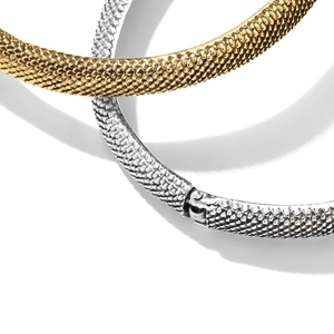 Close-up of gold and silver snake texture bracelets with hinged spring closures