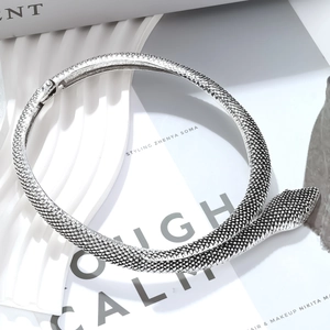 Macro detail of silver snake collar necklace with realistic scale texture and hinge