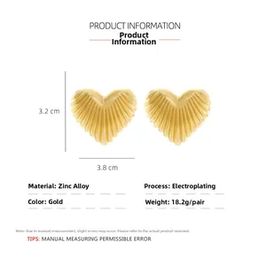 Detail view of heart-shaped gold alloy earrings with pleated texture and dimensions