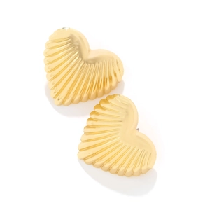 Close-up of heart-shaped gold earrings with shell-like radial texture and metallic finish