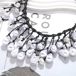 Baroque pearl knot necklace featuring natural pearls with black braided rope design