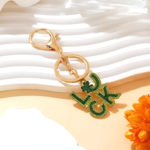 Gold-plated LUCK keychain with green rhinestones and a four-leaf clover lucky charm
