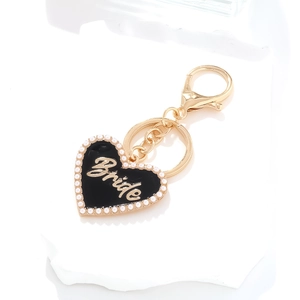 Detail of heart-shaped black enamel Bride pendant with pearls and golden hardware