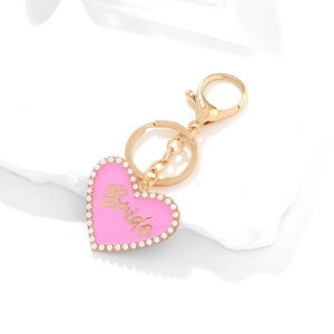 Detail of pink enamel heart keychain with Bride lettering and pearl trim on white stone