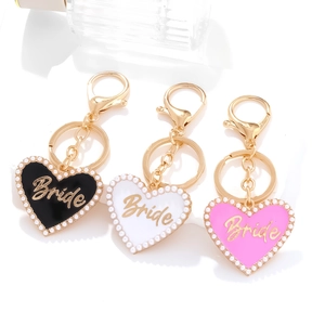 Detailed view of heart-shaped Bride keychains with pearls in black, white and pink colors