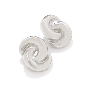 Macro view of silver twisted knot earrings with polished metallic mirror finish