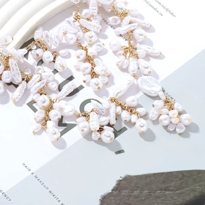 Handmade baroque pearl necklace set with golden metal rings on white background