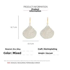 Detail view of large C-shaped shell drop earrings with dimensions of 6.7cm by 4.4cm