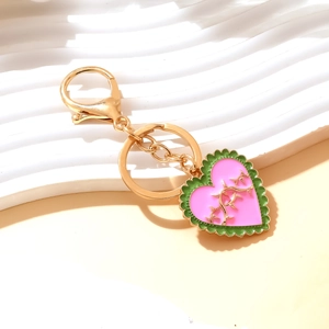 Pink heart keychain with green enamel trim and gold branch pattern on lobster clasp